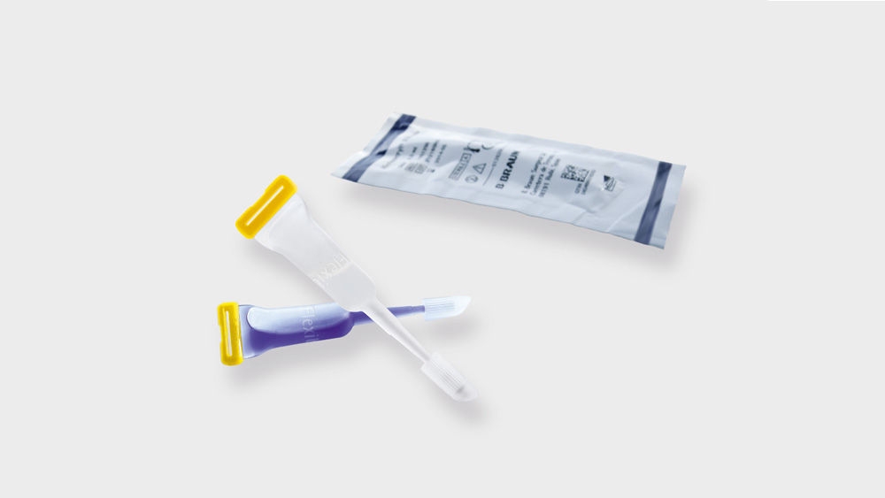 Sterile medical sampling swabs with yellow caps and a sealed pouch, isolated on a light background.